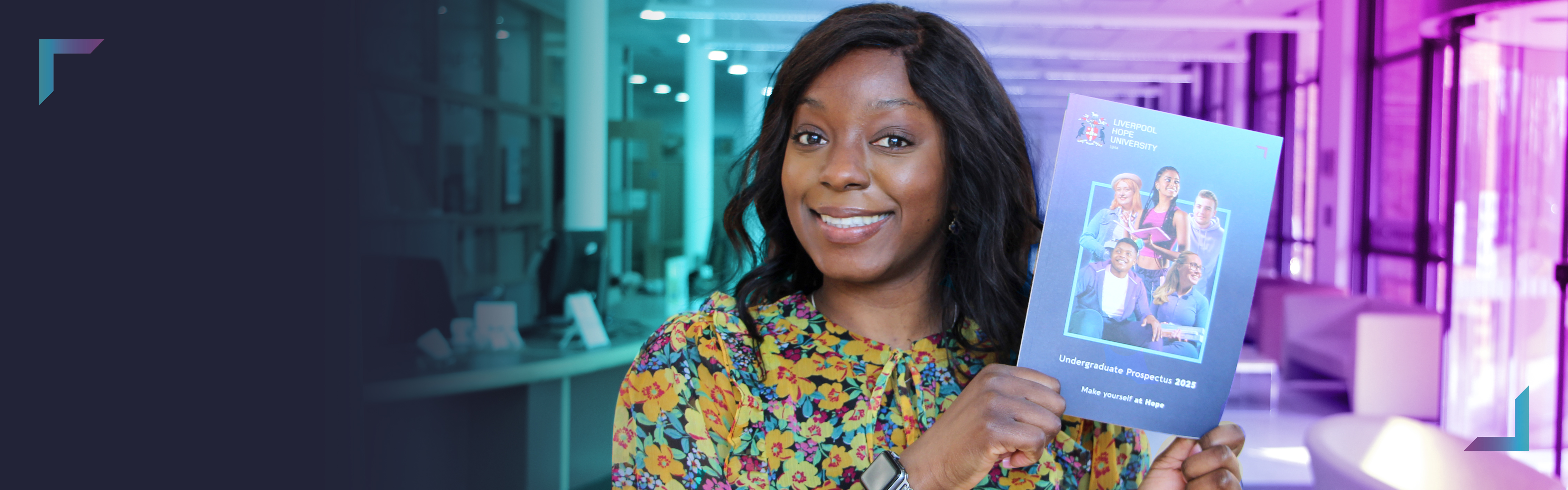 Staff member holding new prospectus to camera and smiling